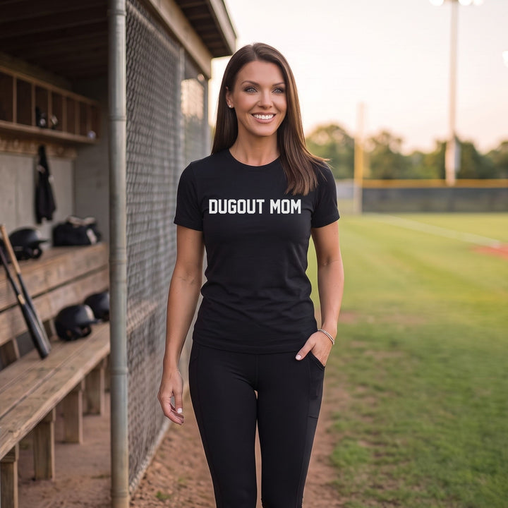 A woman stands on a baseball field wearing a RIPPASHOT black t-shirt with &