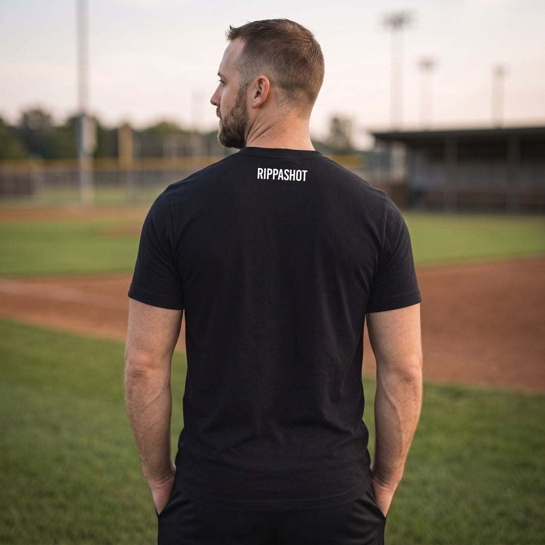 A man viewed from behind wearing a RIPPASHOT black t-shirt with &